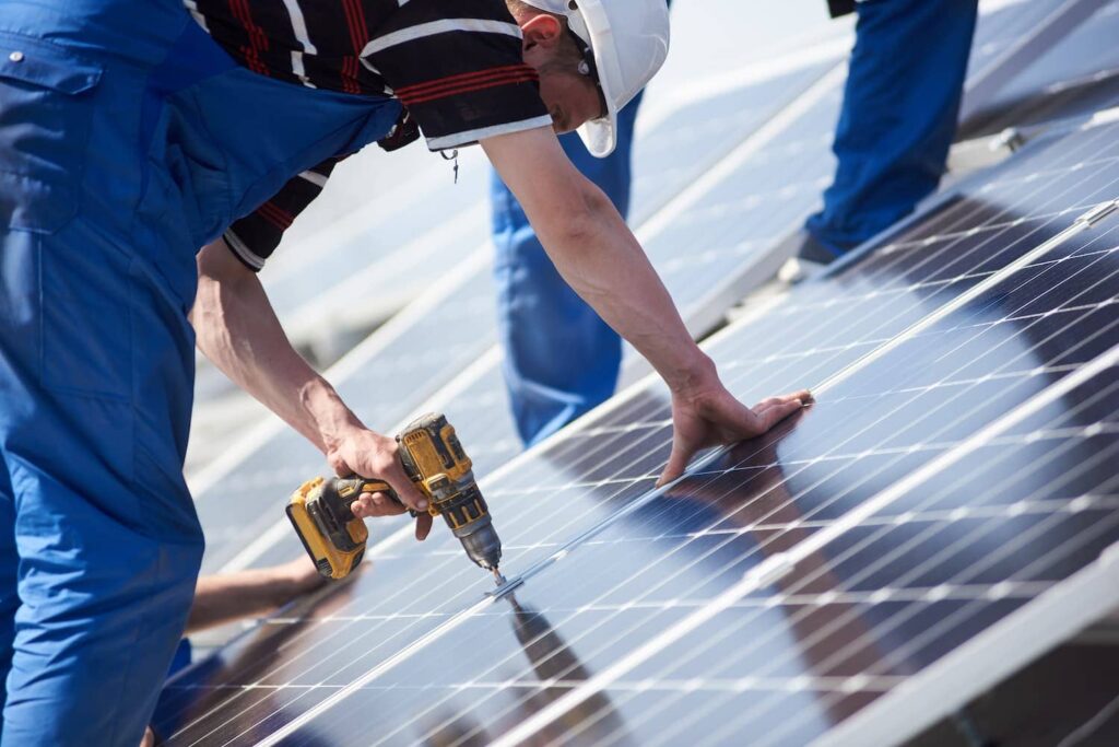 électriciens installant des panneaux solaires sur un toit